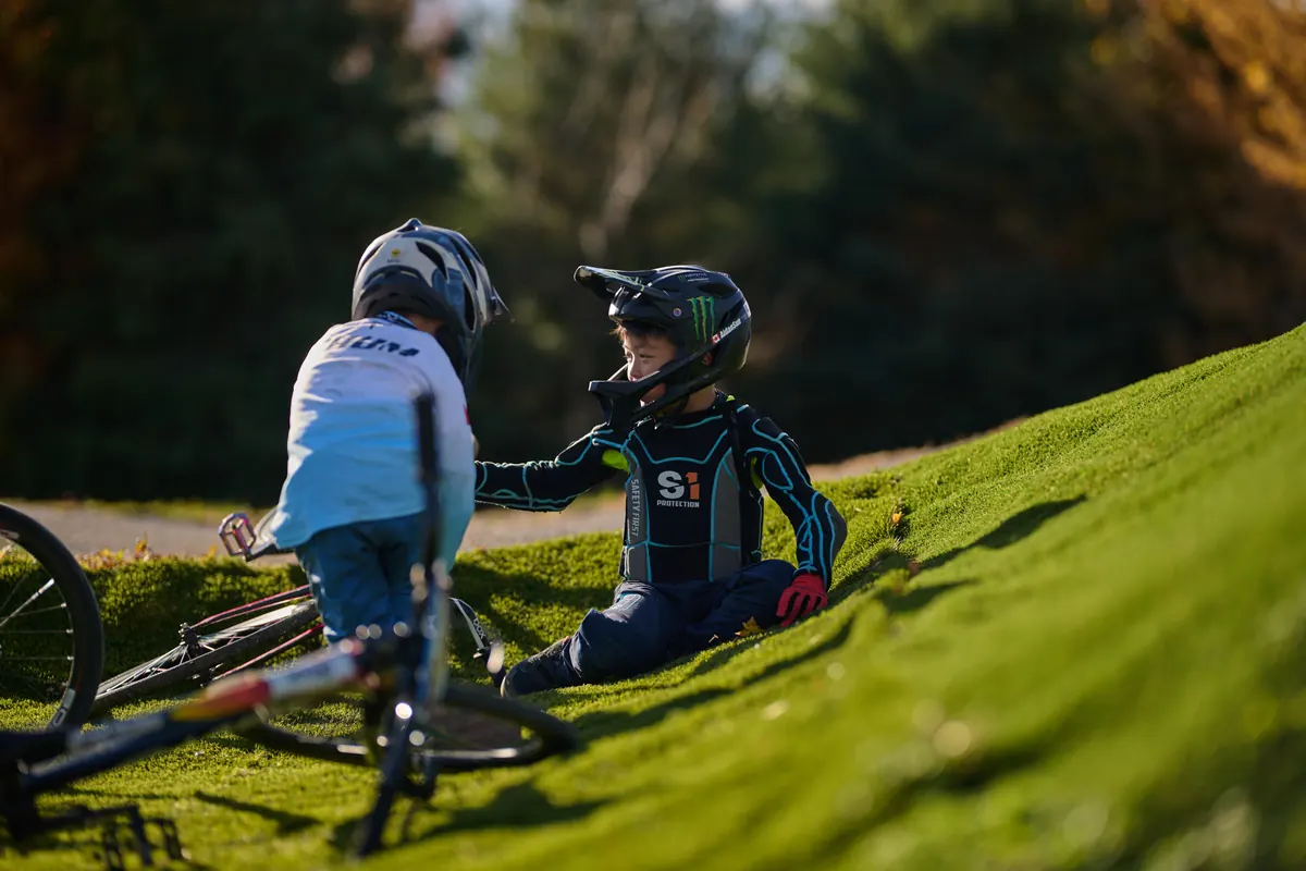 Two young XKIDS riders together at a track in race kit.
